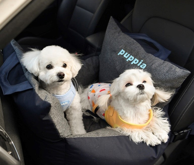 Perro descansando plácidamente en la Silla Puppia mientras viaja, mostrando cómo la silla funciona como cama portátil para viajes largos.