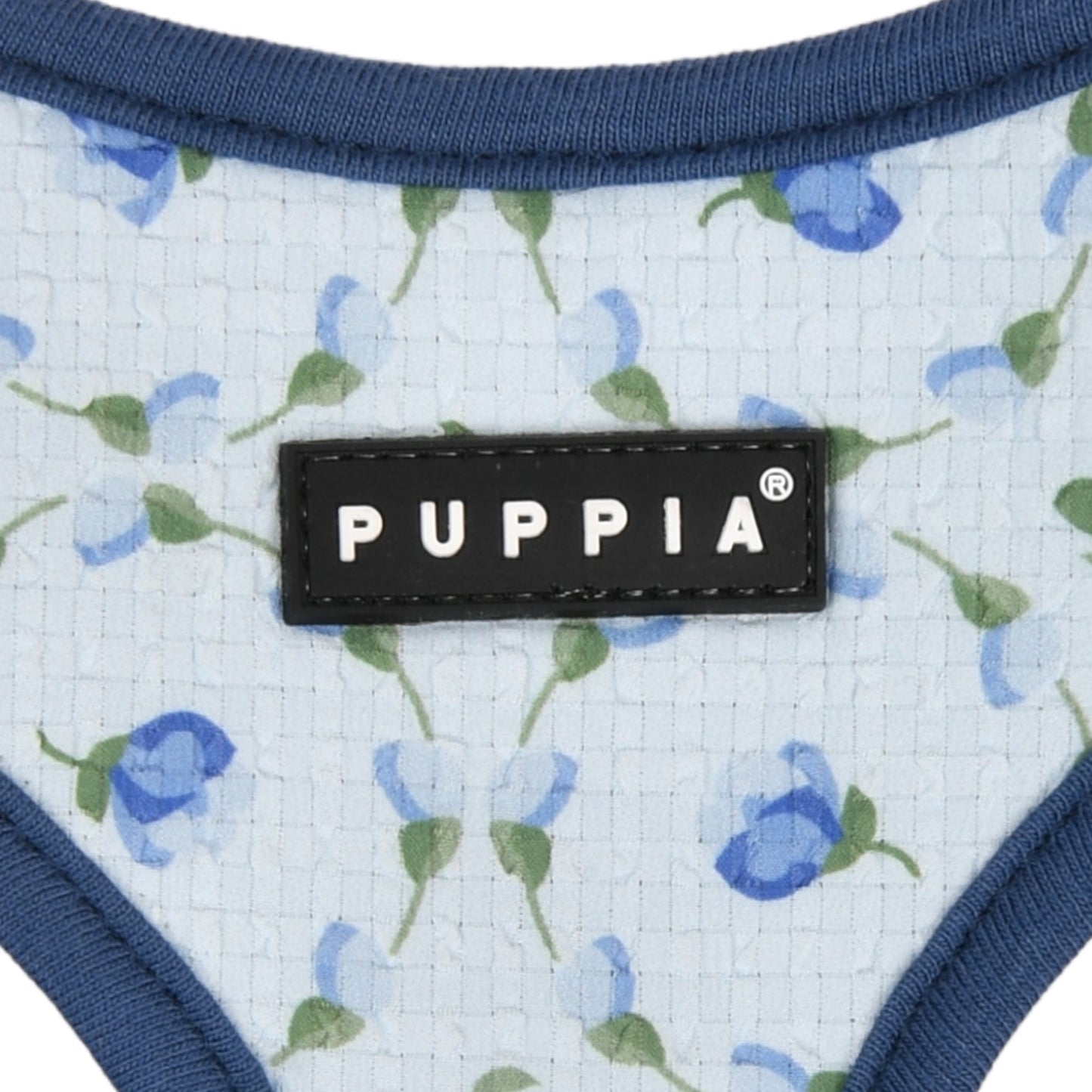 Perro pequeño con el Arnés Florian de Puppia, luciendo su diseño con florecitas frescas y ajuste cómodo para paseos veraniegos.